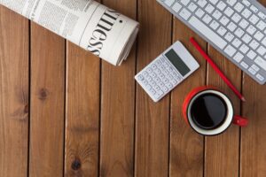 image of a newspaper, calculator, cup of coffee and a keyboard